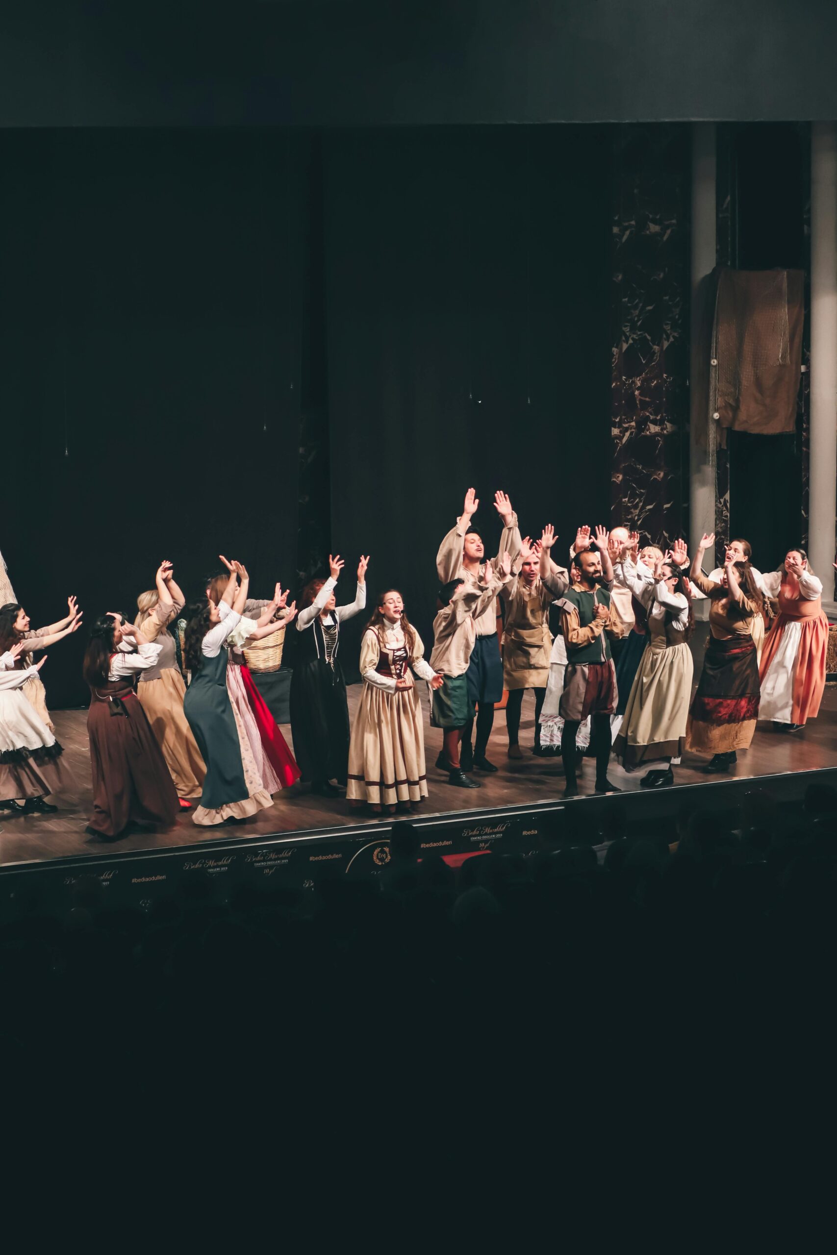 Diverse group of actors performing a theatrical play in İzmir, Turkey. Energetic stage scene.